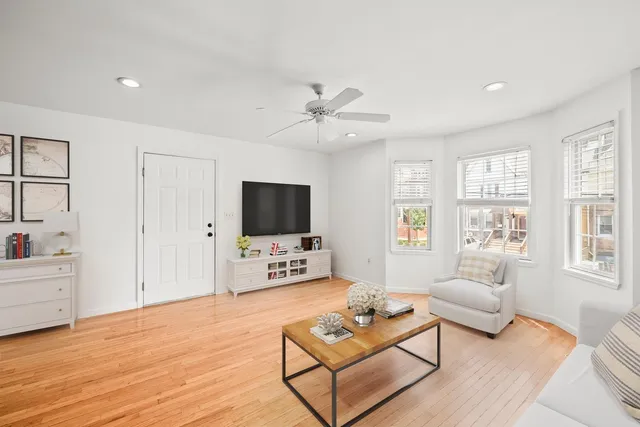 a living room with furniture a flat screen tv and a large window