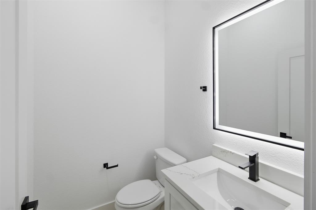 1115 Riverwood Road Dallas, TX 75217 - Photo 25 of 39 Half bathroom featuring vanity and a textured wall