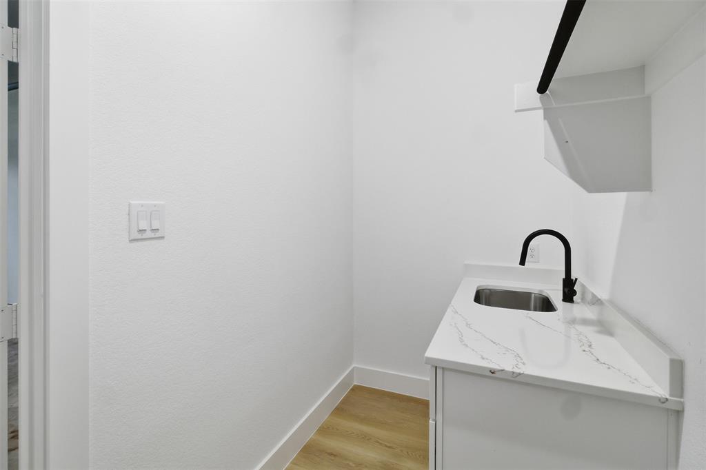 1115 Riverwood Road Dallas, TX 75217 - Photo 27 of 39 Washroom featuring a sink and light wood finished floors