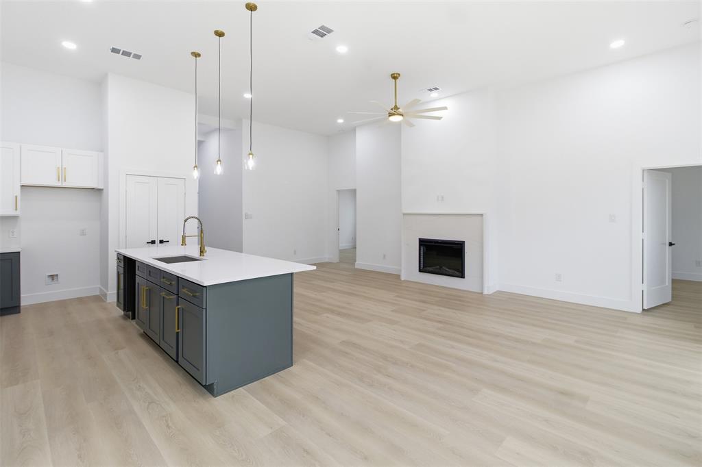 1115 Riverwood Road Dallas, TX 75217 - Photo 38 of 39 Kitchen with a high ceiling, gray cabinetry, open floor plan, white cabinetry, and decorative light fixtures