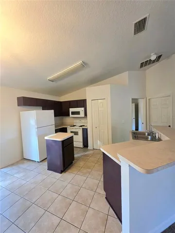 a kitchen with a stove a refrigerator and a sink
