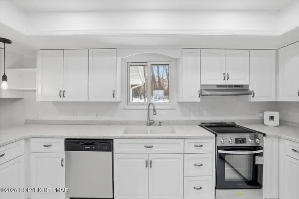 a kitchen with granite countertop white cabinets and white appliances