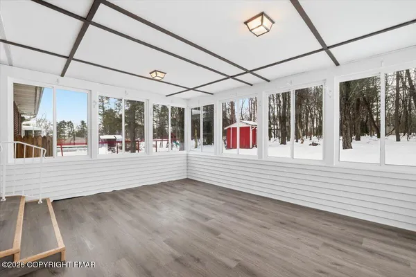 an empty room with wooden floor and ceiling fan