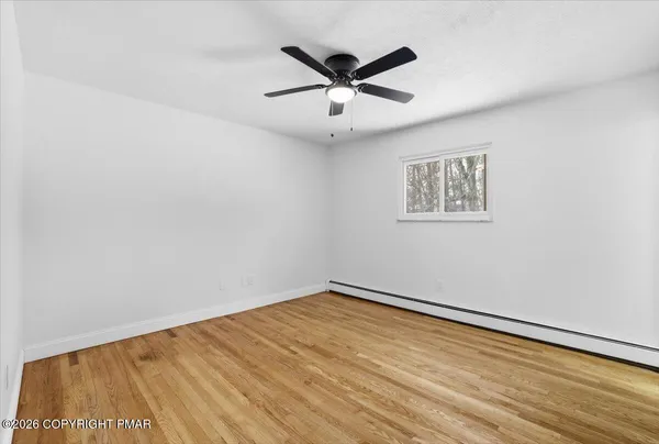 a view of empty room with wooden floor