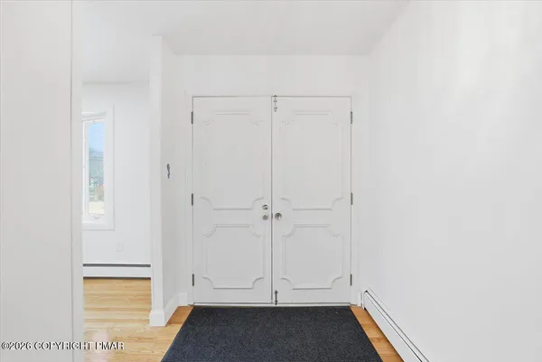 a view of an empty room with a fireplace and a window