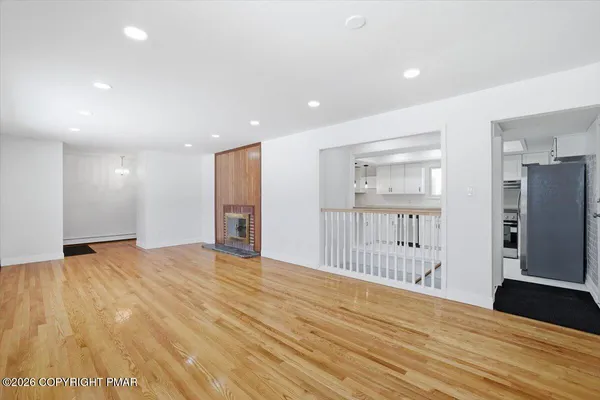 a view of an empty room with a fireplace and a window