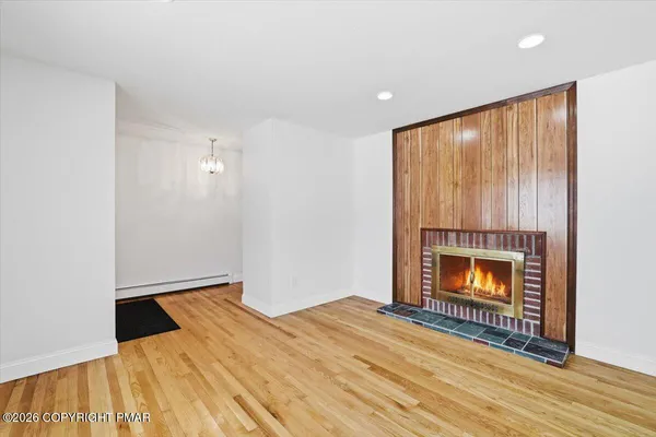 a view of empty room with wooden floor and ceiling fan