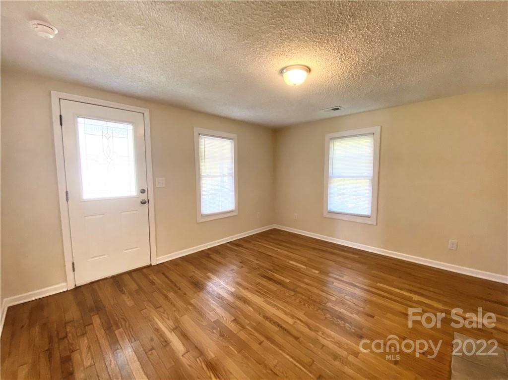 3367 Deerbrook Road Lenoir, NC 28645 - Photo 7 of 13 an empty room with wooden floor and windows
