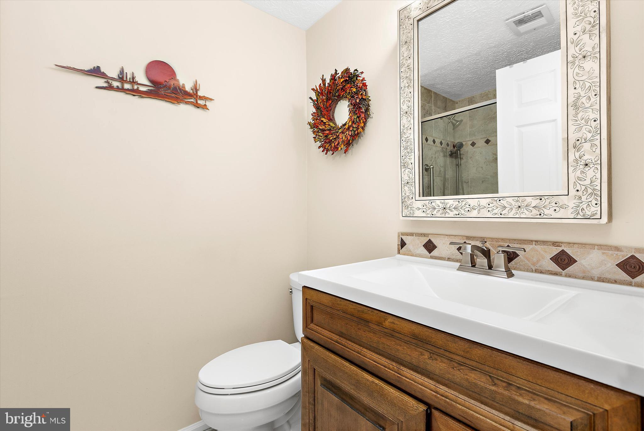 679 Deering Road, Unit 4D Pasadena, MD 21122 - Photo 18 of 28 a bathroom with a sink mirror vanity and toilet