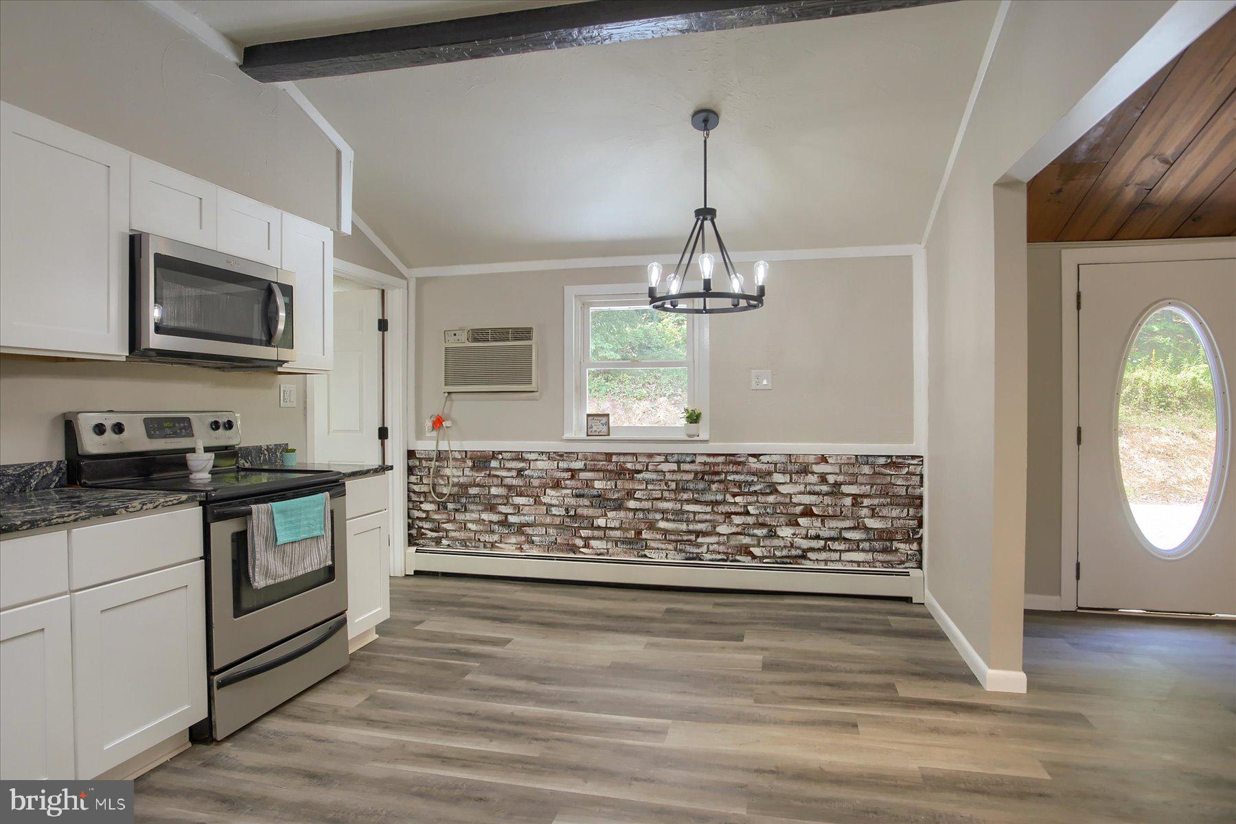 1441 Erney Road Dover, PA 17315 - Photo 11 of 45 a kitchen with stainless steel appliances kitchen island granite countertop a stove and a wooden floors