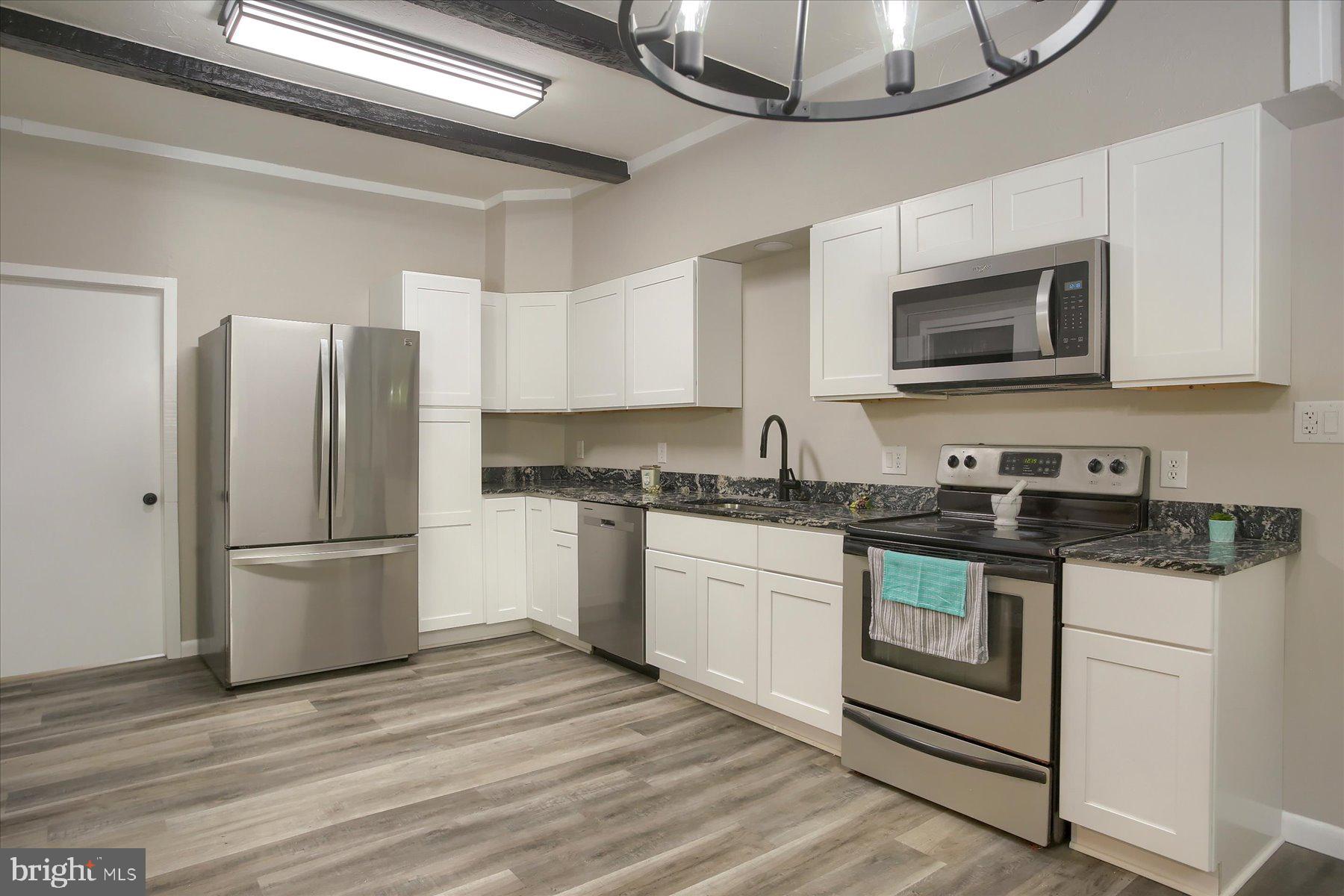 1441 Erney Road Dover, PA 17315 - Photo 13 of 45 a kitchen with stainless steel appliances granite countertop a refrigerator stove a sink and a microwave