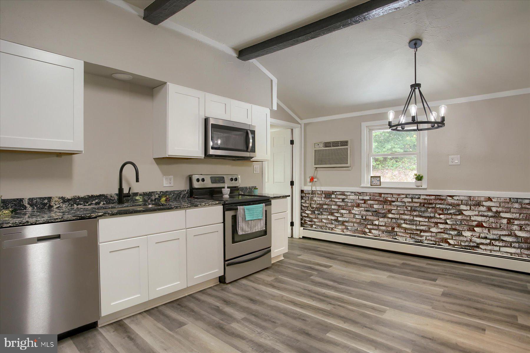 1441 Erney Road Dover, PA 17315 - Photo 10 of 45 a kitchen with granite countertop a stove a sink and a microwave