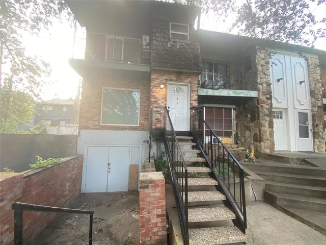 a view of a house with a small yard and wooden floor and fence