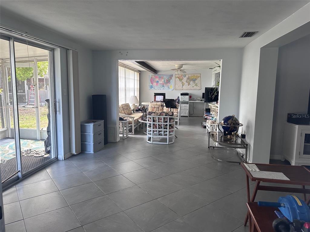 3542 Delta Place Holiday, FL 34691 - Photo 18 of 28 a living room with furniture a flat screen tv and a floor to ceiling window