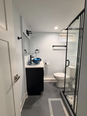 a bathroom with a granite countertop sink toilet and shower