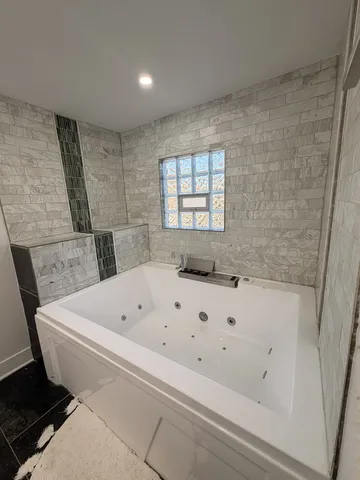 a view of a livingroom with a flat screen tv wooden floor and a ceiling fan