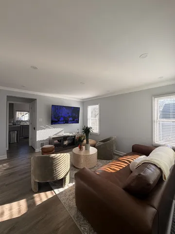 a kitchen with stainless steel appliances a stove a sink dishwasher a microwave oven a refrigerator with grey cabinets and wooden floor