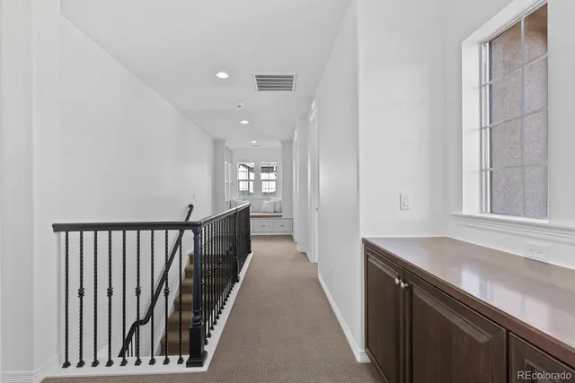 a view of a hallway with wooden floor and staircase