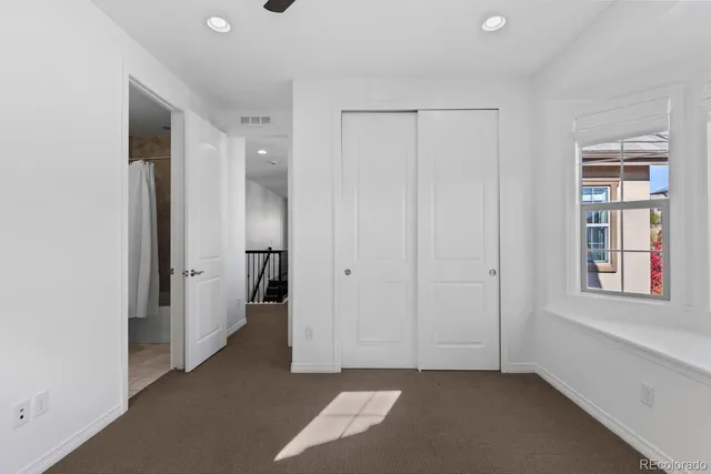 an empty room with windows and closet