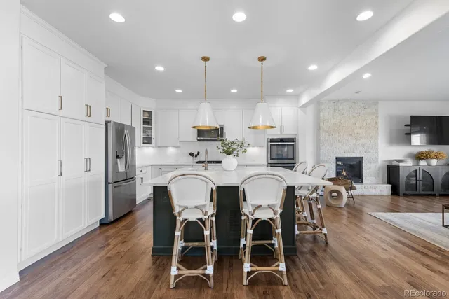 a kitchen with refrigerator a sink and chairs