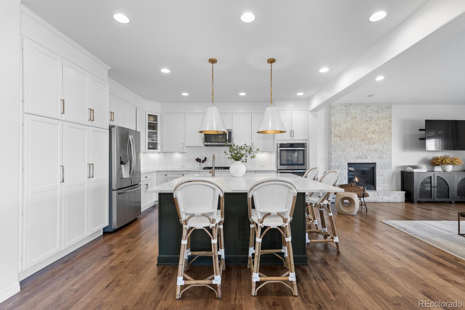 10699 Timberdash Avenue Highlands Ranch, CO 80126 - Photo 6 of 50 a kitchen with refrigerator a sink and chairs
