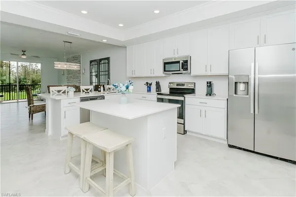 a kitchen with white cabinets and stainless steel appliances