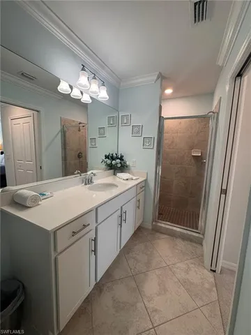 a spacious bathroom with a shower a sink and a mirror
