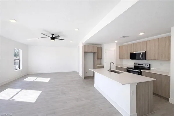 a kitchen with a sink a counter top space and stainless steel appliances