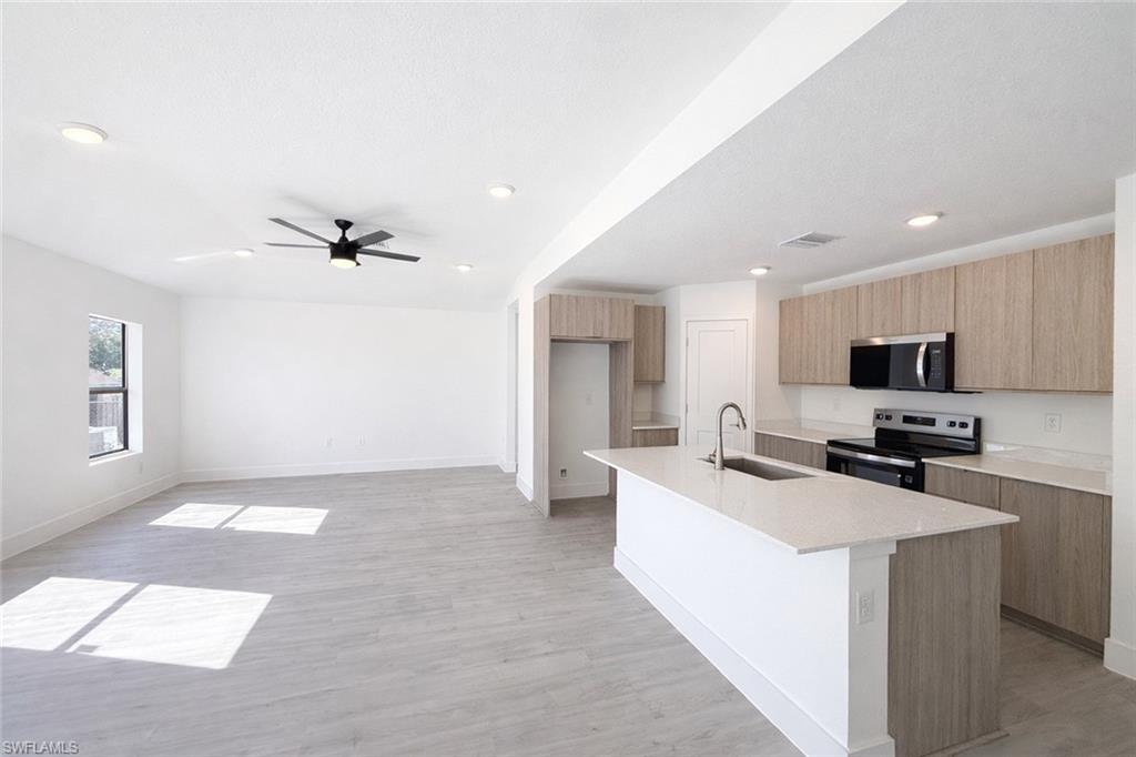 2709 22nd Street Southwest Lehigh Acres, FL 33976 - Photo 1 of 18 a kitchen with a sink a counter top space and stainless steel appliances