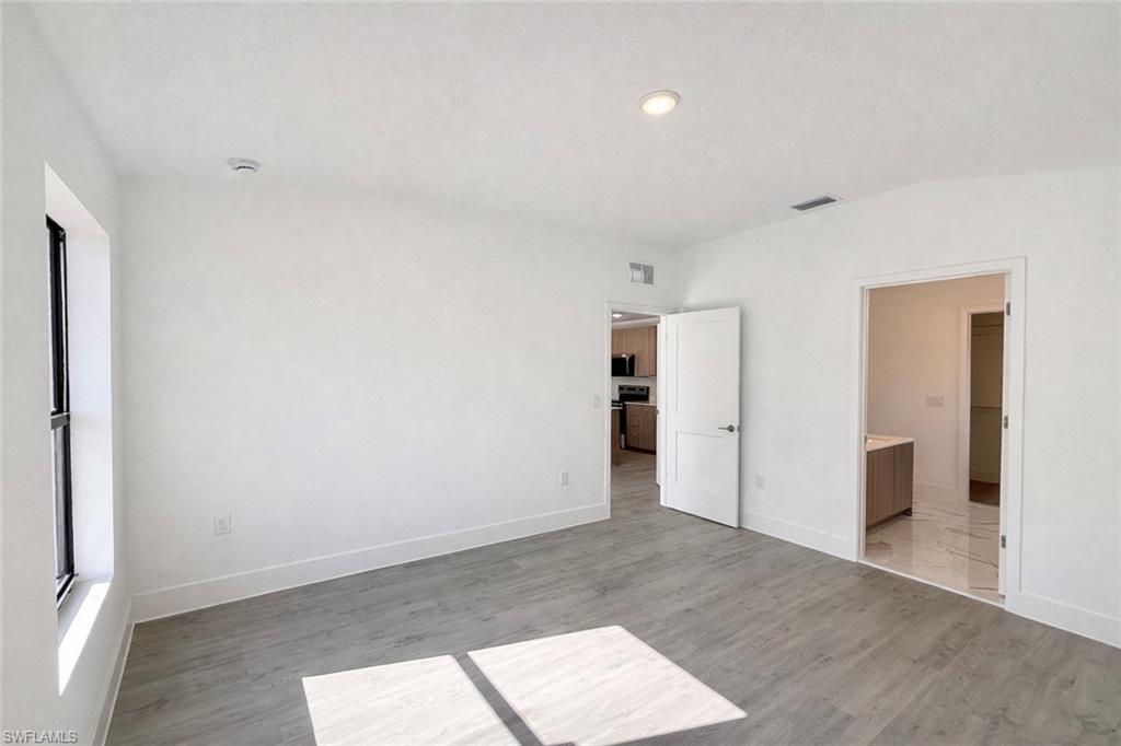2709 22nd Street Southwest Lehigh Acres, FL 33976 - Photo 11 of 18 wooden floor in an empty room