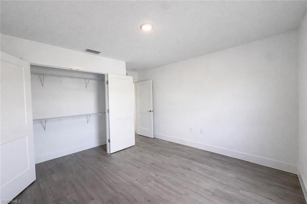 2709 22nd Street Southwest Lehigh Acres, FL 33976 - Photo 12 of 18 an empty room with wooden floor & closet area