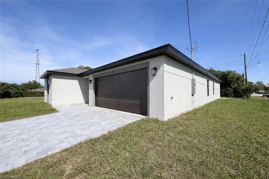 2709 22nd Street Southwest Lehigh Acres, FL 33976 - Photo 3 of 18 a front view of a house with a yard and garage