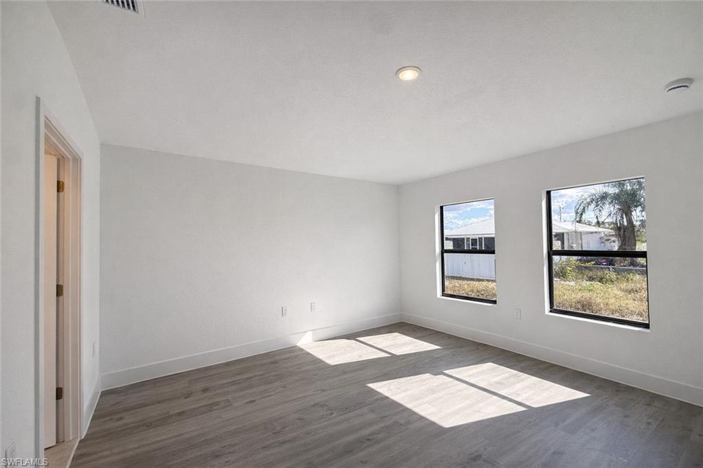 2709 22nd Street Southwest Lehigh Acres, FL 33976 - Photo 6 of 18 wooden floor in an empty room with window