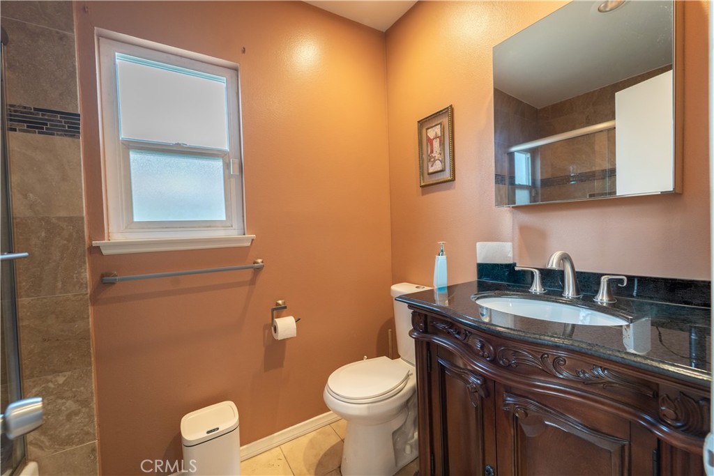 9221 Pico Vista Road Downey, CA 90240 - Photo 12 of 38 a bathroom with a granite countertop toilet sink and mirror