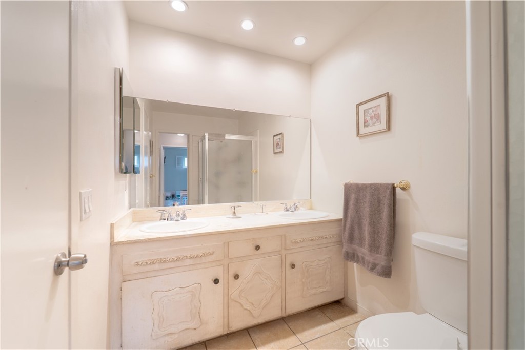 9221 Pico Vista Road Downey, CA 90240 - Photo 16 of 38 a spacious bathroom with a double vanity sink toilet and a mirror