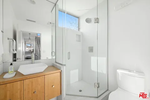 a bathroom with a granite countertop sink toilet and shower