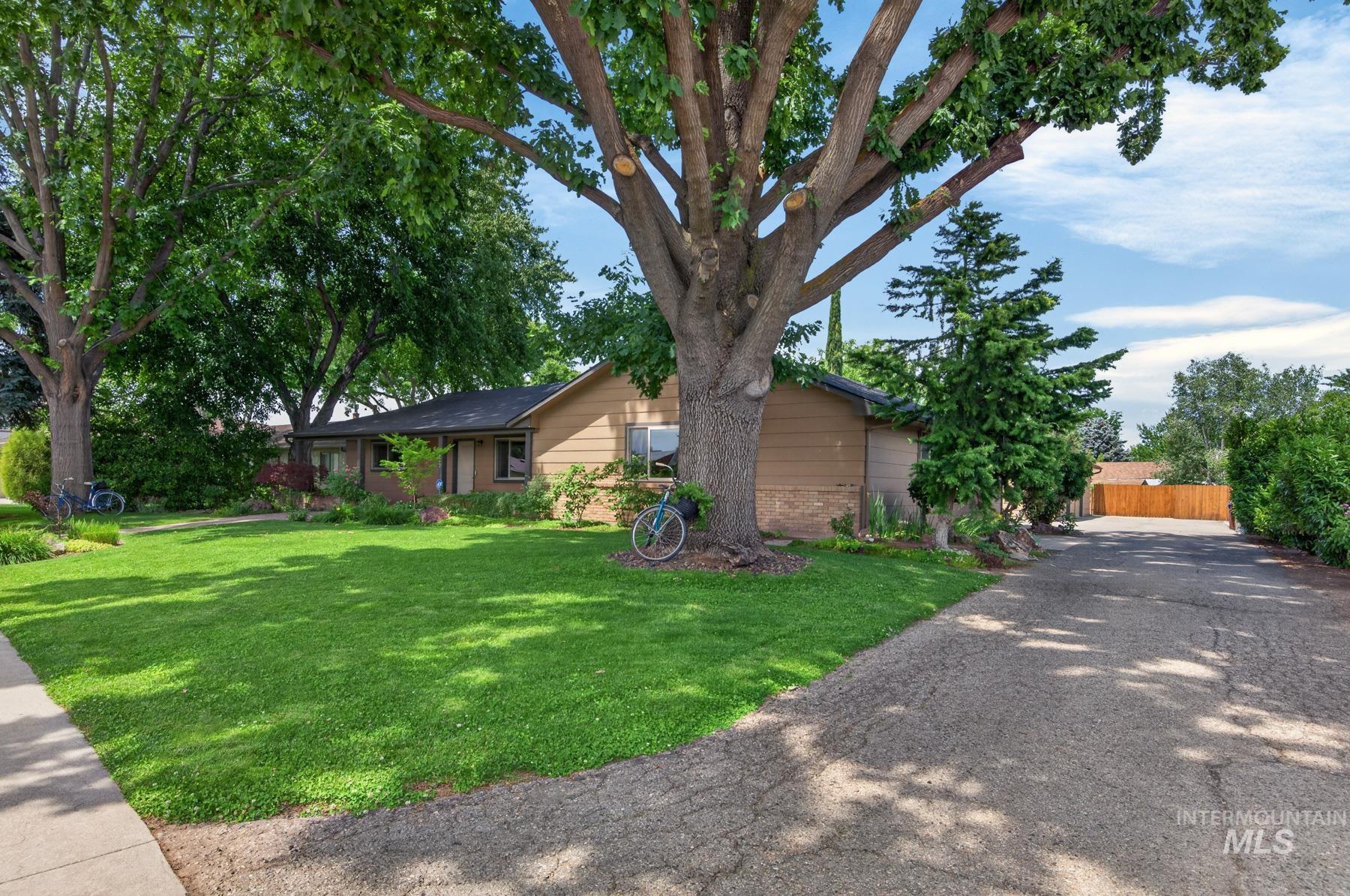 9622 Delaware Street Boise, ID 83709 - Photo 2 of 48 Single-story residence featuring a front yard with mature trees, a manicured lawn, and a paved driveway