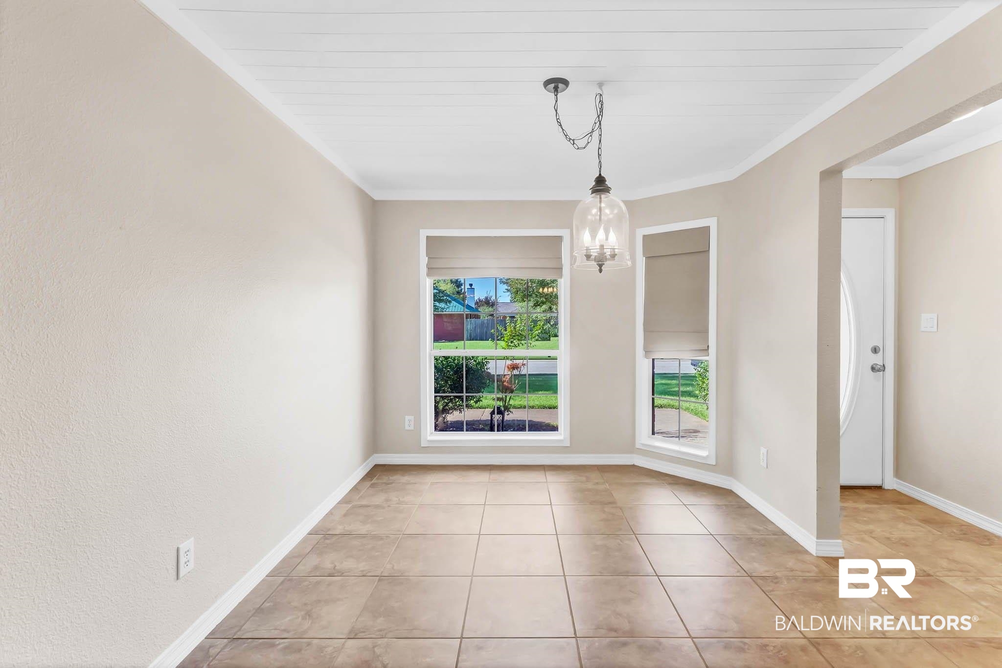9607 Czar Court Fairhope, AL 36532 - Photo 17 of 42 Unfurnished dining area with a chandelier, light tile patterned floors, and crown molding
