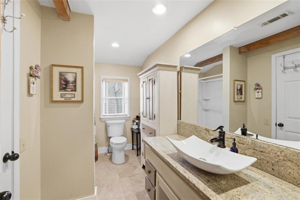 1401 Adair Mill Road Cleveland, GA 30528 - Photo 31 of 62 a bathroom with a granite countertop sink a toilet and a mirror