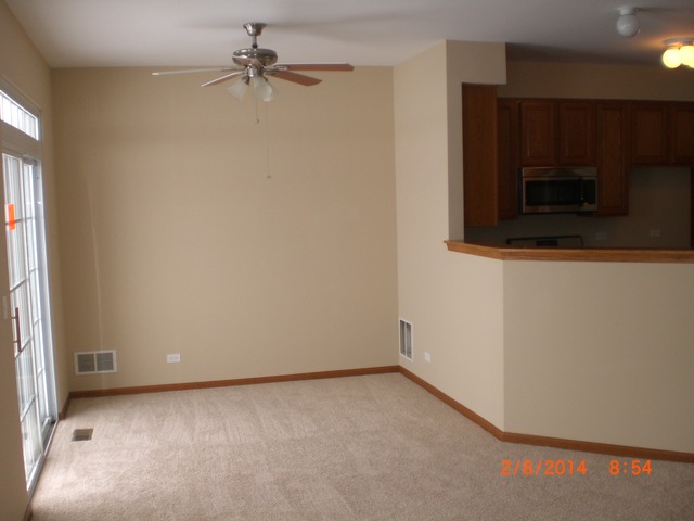 1974 West Cobblestone Road, Unit 3532303 Romeoville, IL 60446 - Photo 7 of 23 an empty room with a ceiling fan and a window