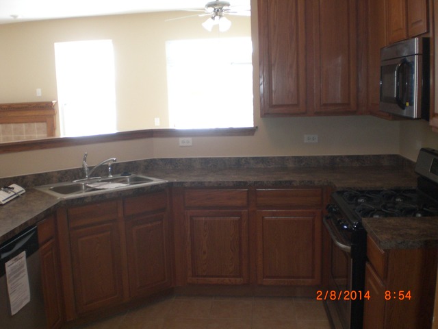 1974 West Cobblestone Road, Unit 3532303 Romeoville, IL 60446 - Photo 10 of 23 a kitchen with granite countertop a sink stove and cabinets