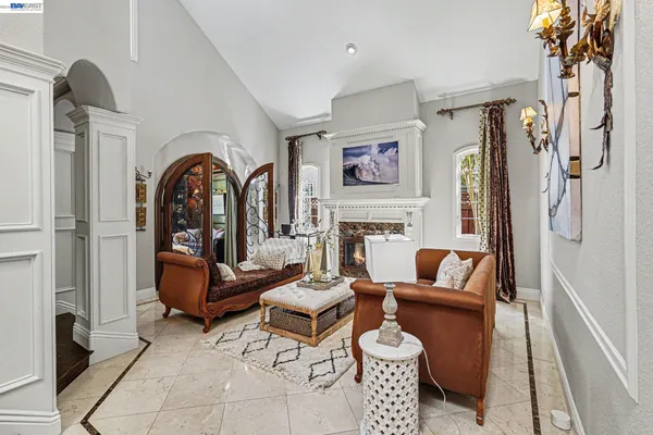 a living room with furniture chandelier and a rug