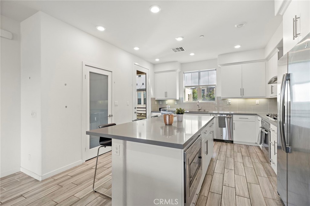 144 Paramount Irvine, CA 92618 - Photo 6 of 43 a kitchen with kitchen island a sink stove and refrigerator