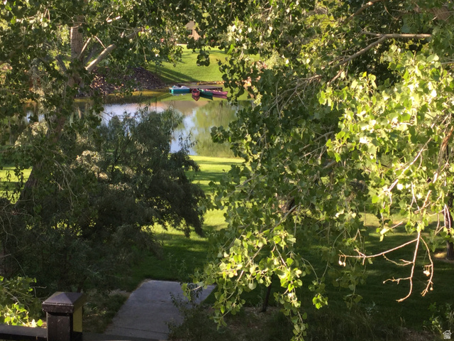 1040 West Mill Road Ferron, UT 84523 - Photo 67 of 117 Lush green foliage frames a tranquil pond with distant boats and a manicured lawn