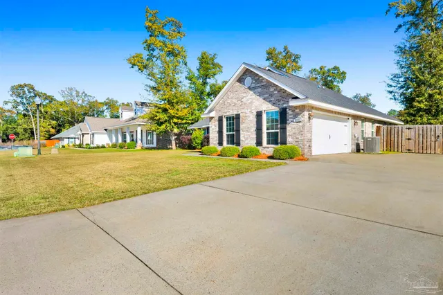 a view of a house with a yard and potted plants