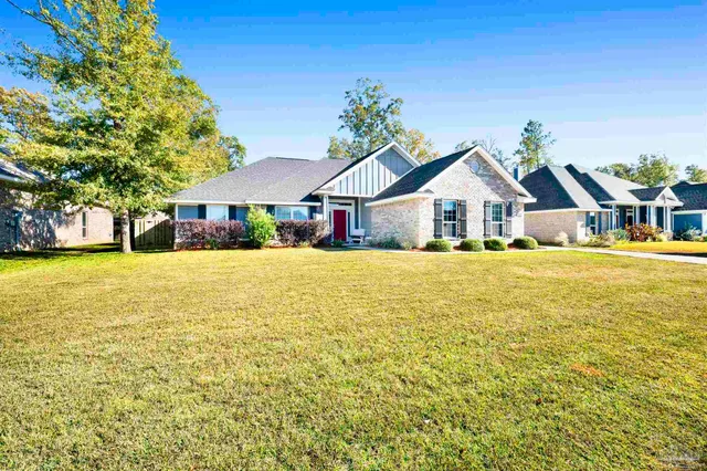 a view of a house with a big yard and large trees