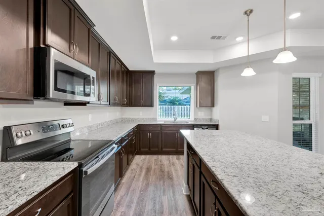a kitchen with stainless steel appliances granite countertop sink stove and microwave