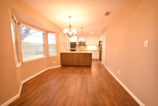 a kitchen with kitchen island granite countertop wooden cabinets and stainless steel appliances