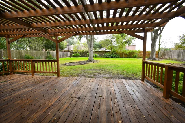 a patio with wooden floor a yard tables and chairs