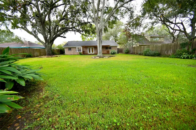 a front view of a house with a garden and trees